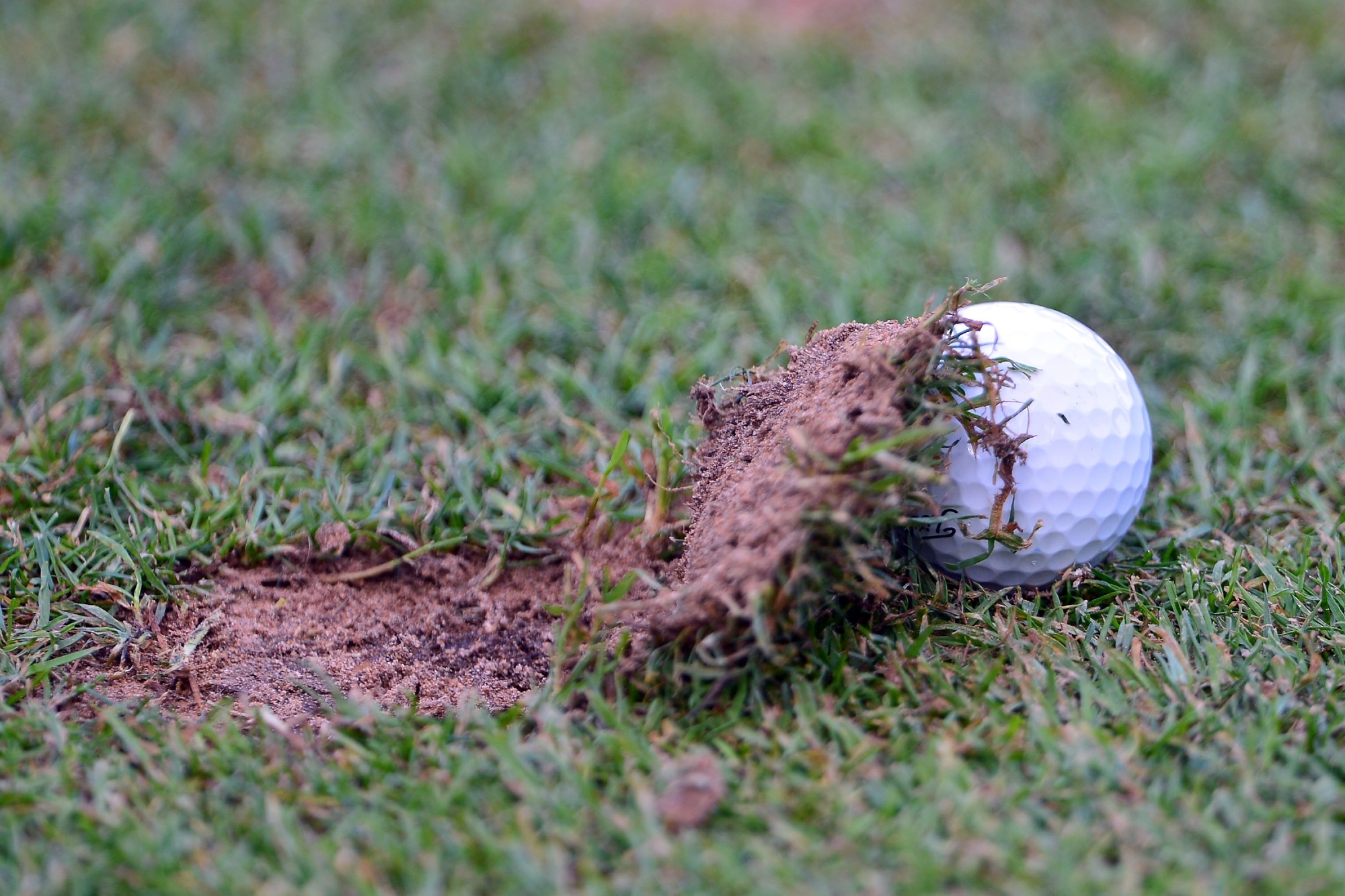 Golf ball under a divot