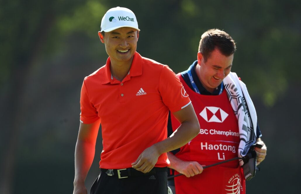 caddie standing behind player