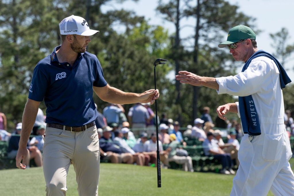 Sam Burns of the United States hands his putter to his caddie Travis Perkins on the No. 18 green during the first round of the Masters at Augusta National Golf Club, Thursday, April 09, 2026 | Source: Getty