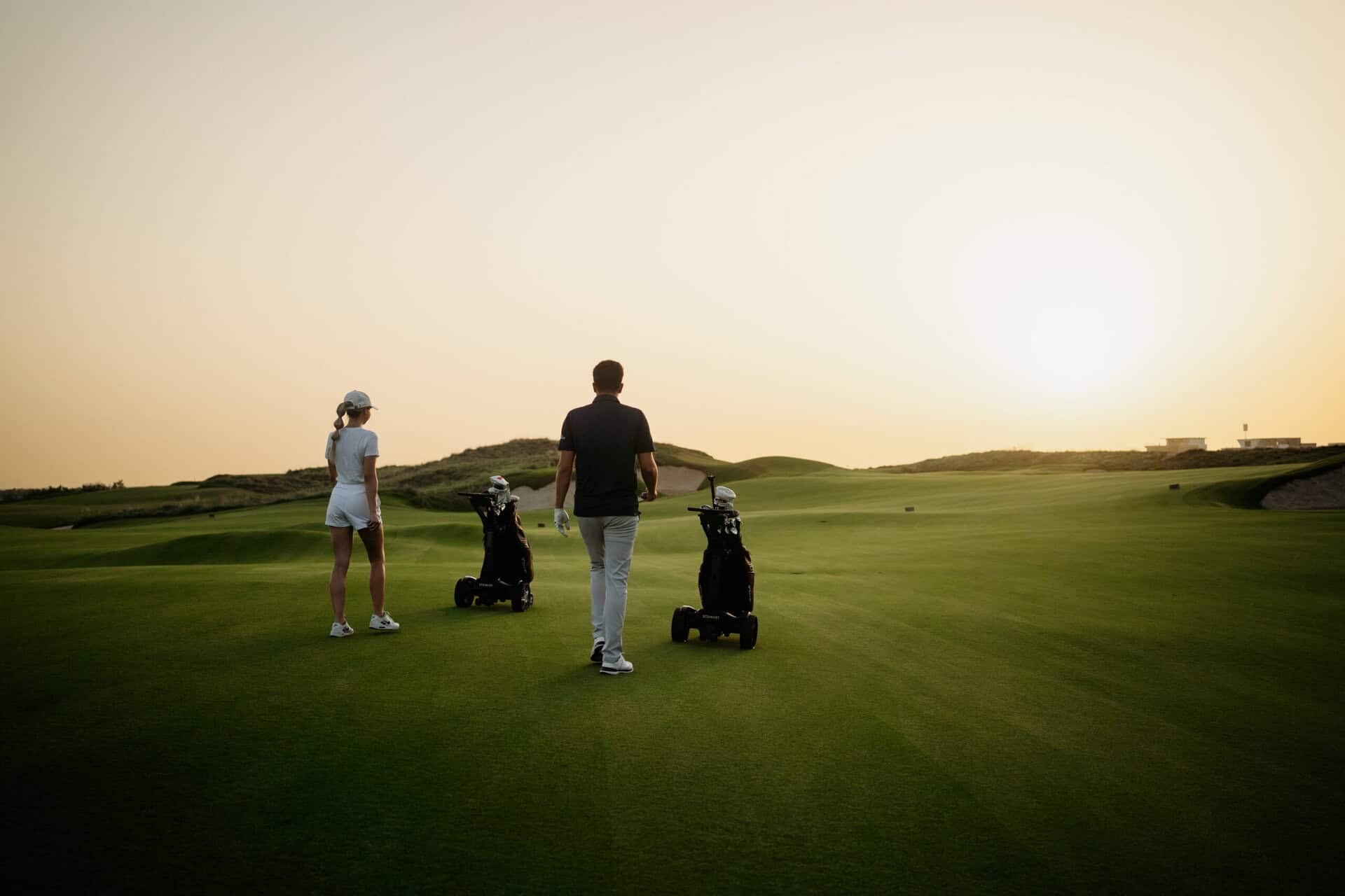 A sunset view as golfers walk the fairway along with their Stewart Golf trolleys | Source: Stewart Golf