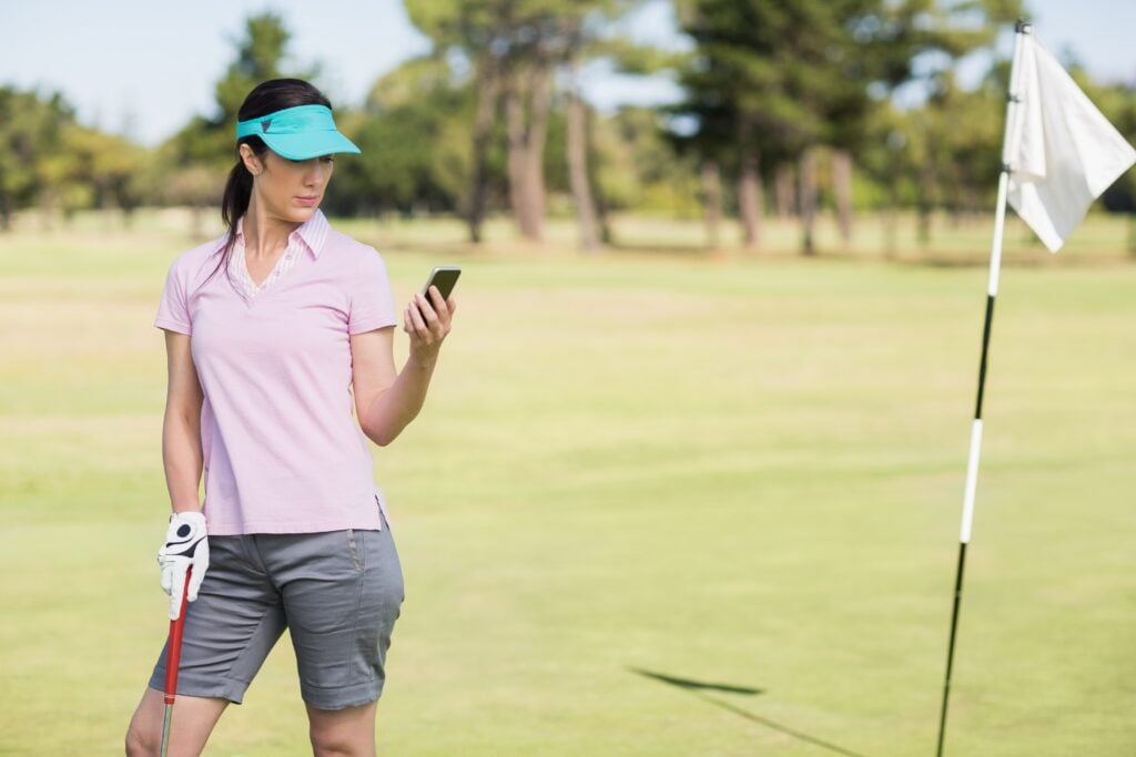 A golfer uses their phone on the course | Source: Adobe Stock mobile phones on the golf course