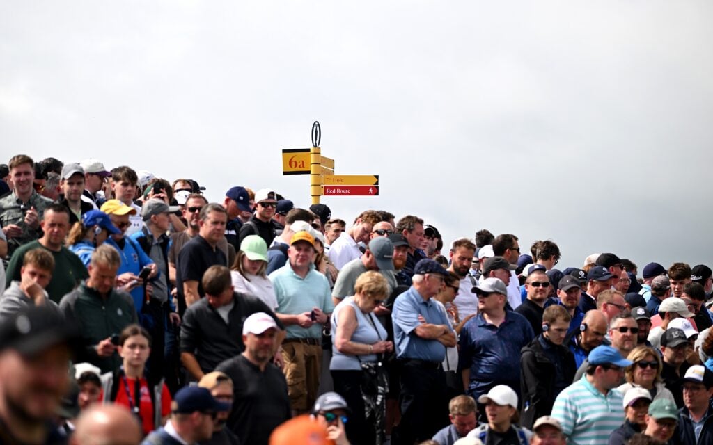 Crowds look on during The Open at Royal Portrush | Source: The R&A/via Getty Images spectator picks up golf ball