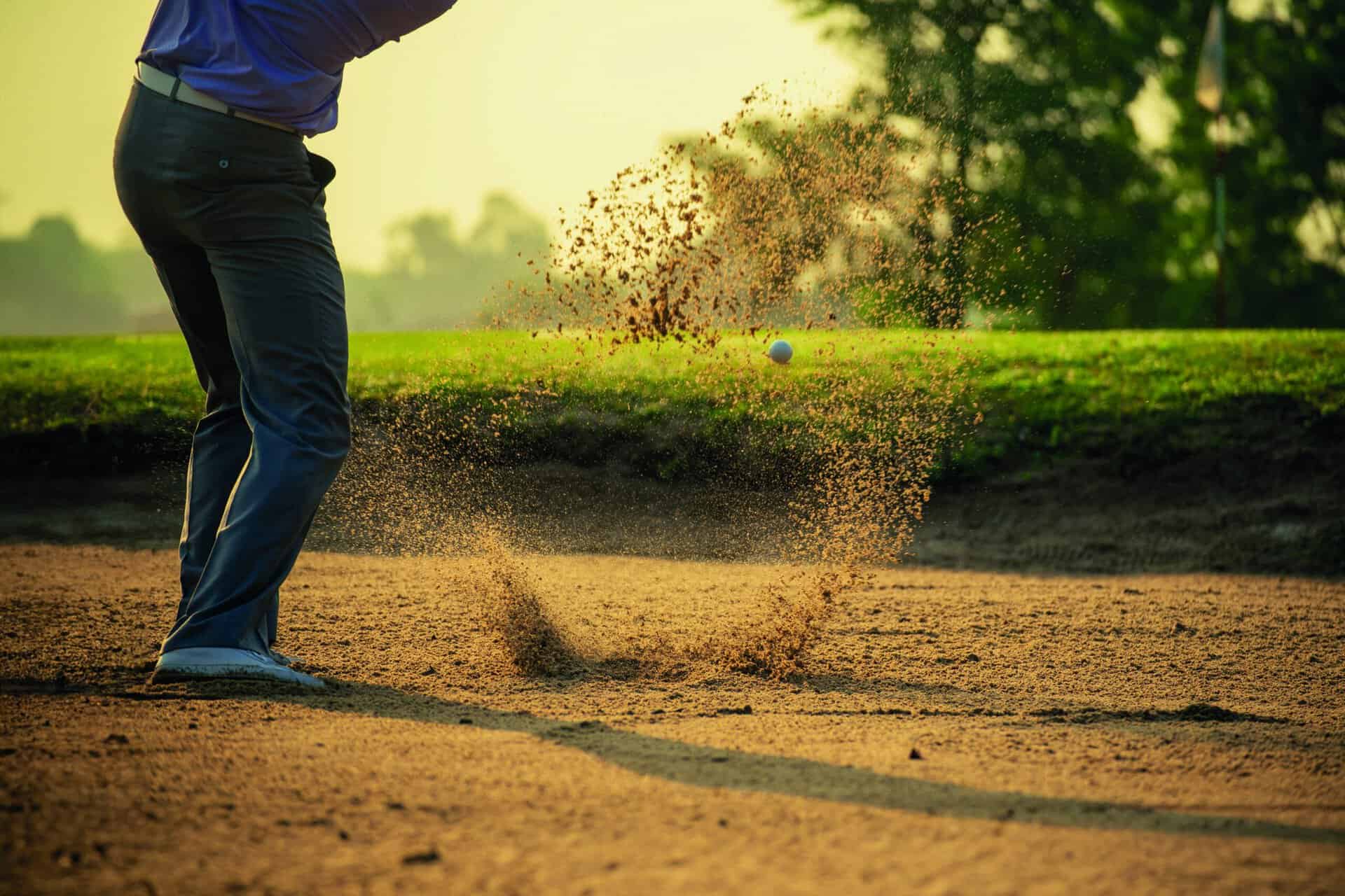 A golfer takes a shot from a bunker | Source: Adobe Stock how much does a bunker cost?