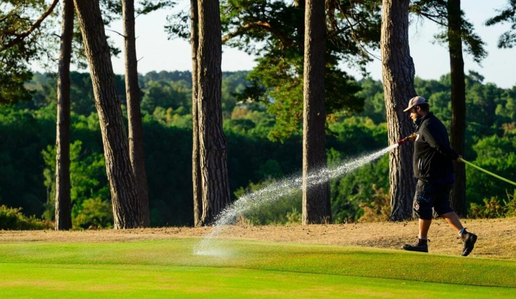 A greenkeeper irrigates a green | Source: Leaderboard Photography