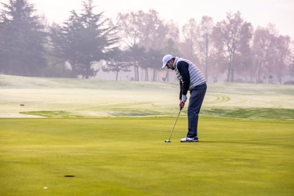 A player hits a putt amid the backdrop of icy conditions on the course | Source: Adobe Stock