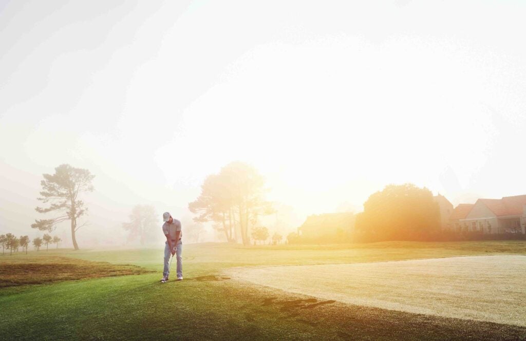 A golfer chips onto the green in dewy conditions | Source: Adobe Stock
dew on the green